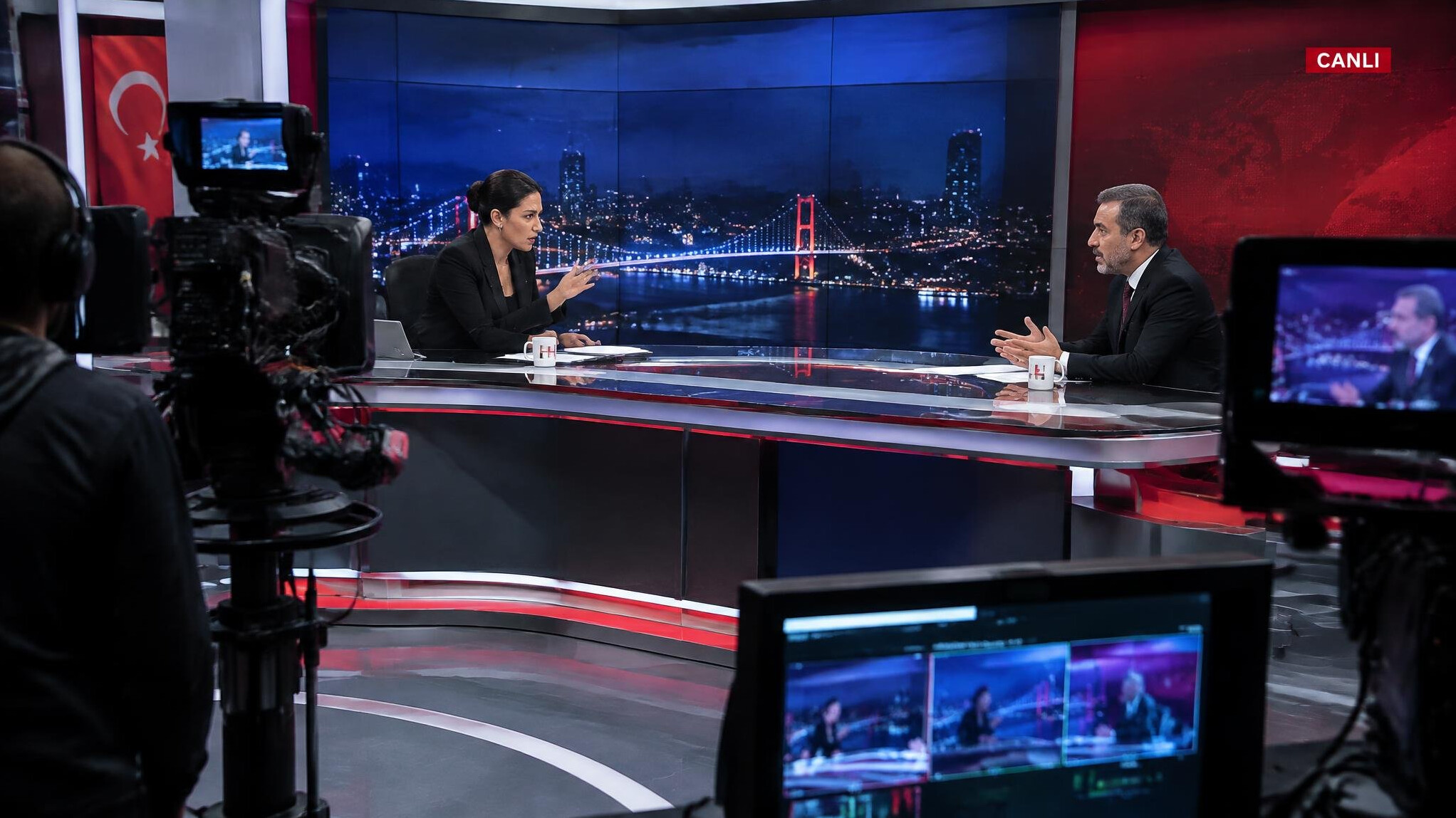 Tense moment between a news anchor and a guest in a TV studio during a live broadcast