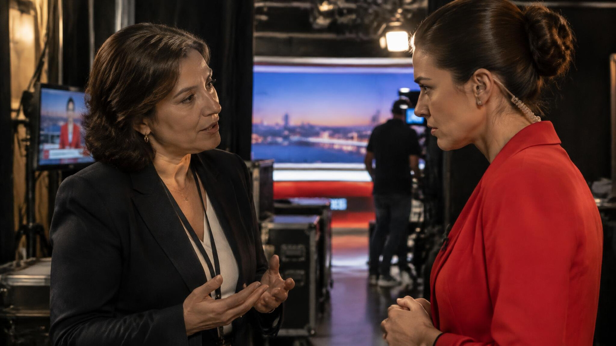 Mediator calmly speaking with a news anchor before a live broadcast
